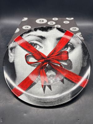une assiette sur laquelle est représentée une femme avec un ruban rouge