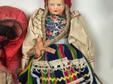 two dolls are sitting next to each other on a white surface