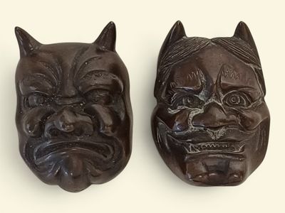 deux sculptures de chats marron sur une surface blanche