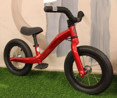 a small red bike that is sitting on the grass