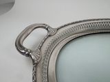 a silver oval mirror with a handle on the wall