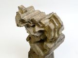 une sculpture en pierre posée sur une surface blanche