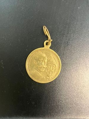 une pièce d'or sur laquelle est représenté un visage, posée sur une surface noire