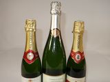 three bottles of champagne sitting next to each other on a table