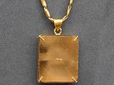 a close up of a gold plated necklace with a chain
