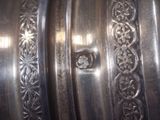 a close up view of a silver vase with designs on it