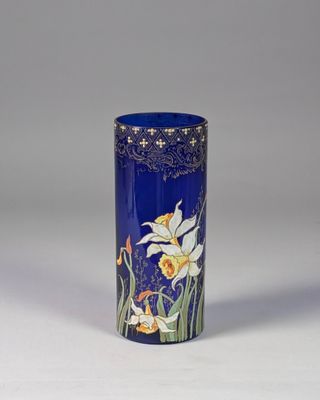 a blue vase with flowers on it on a white surface