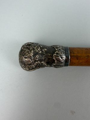 un bâton en bois avec une poignée en métal sur une surface blanche