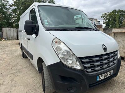 La camionnette blanche est garée sur la terre battue du parking.