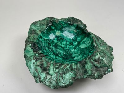 un gros plan d'un bol vert posé sur une surface blanche