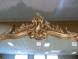 a mirror with a gold frame in a room