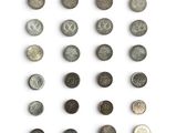 a group of old coins on a white surface with a white background