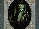 portrait of a man in a tuxedo holding a bouquet of flowers