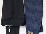 two men ' s pants hanging on a clothes hanger on a white wall