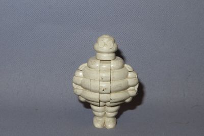 a small white figurine of a man with a hat on
