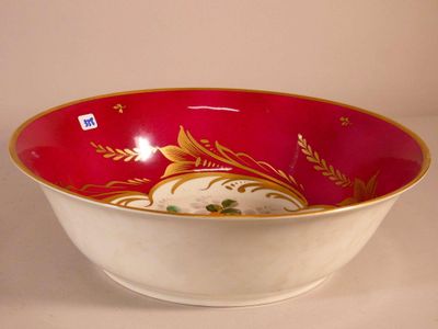 a red bowl with gold designs on it sitting on a table