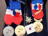 deux médailles et une médaille dans un écrin posé sur une table