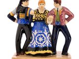 trois figurines représentant un homme et une femme, posées sur un socle en bois