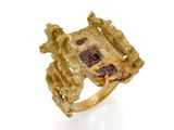 un gros plan d'une bague en or sertie d'une pierre