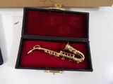 a gold saxophone in a black box on a white table