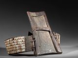 une chaise en bois dans laquelle se trouvent tout un tas de livres