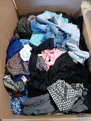 une boîte pleine de vêtements posée sur le sol