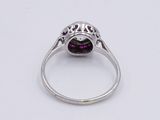 a close up of a ring with a purple stone in it