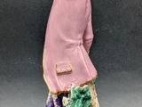 a figurine of a man holding a flower