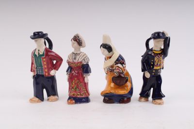 three figurines of people dressed in traditional clothing and hats