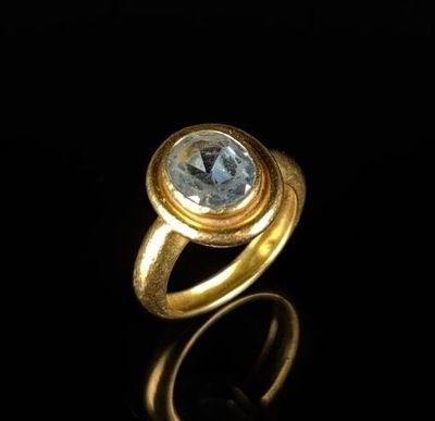 a close up of a gold ring with a blue topaz stone
