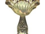 a silver spoon with a shell shaped handle on it