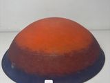 an orange and blue bowl sitting on a white surface