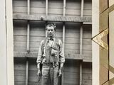 a black and white photo of a man standing in front of a building
