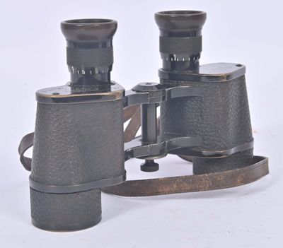 an old pair of binoculars sitting on top of a white surface
