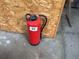 a fire extinguisor sitting next to a wall