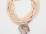 a close up of a necklace on a white surface