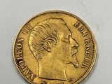 a close up of a gold coin on a white surface