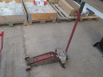 un scooter posé par terre devant une pile de palettes