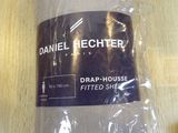 a bag of drab - house fitted sheets on a table