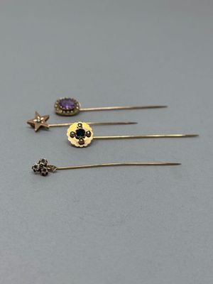 trois paires de boucles d'oreilles en or et en améthore sur un fond gris