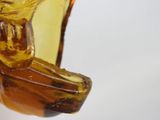 a yellow glass vase with a bird on top of it