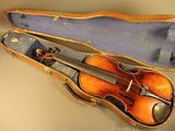 un violon dans son étui, posé sur une table