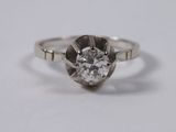 a close up of a diamond ring on a white surface