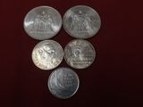 quatre types différents de pièces d'argent sur un fond rouge