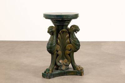 une table verte avec un plateau en marbre posée sur un sol en ciment