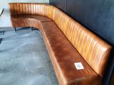 un banc en cuir marron dans un coin de la pièce