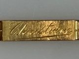 an image of a close up of a gold bracelet on a white surface