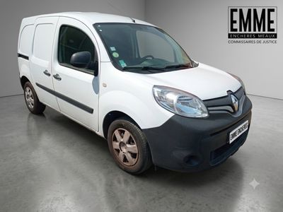 La petite camionnette blanche est garée dans une grande pièce.