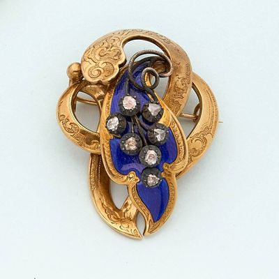 a gold brooch with blue and white stones on it