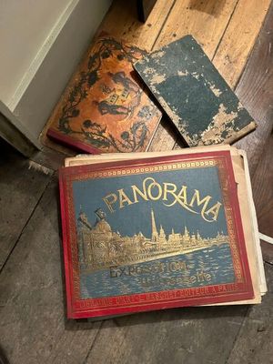 an old book sitting on the floor next to a pile of books